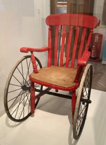 A 19th century wheelchair, a hybrid of a Windsor chair and pram wheels.