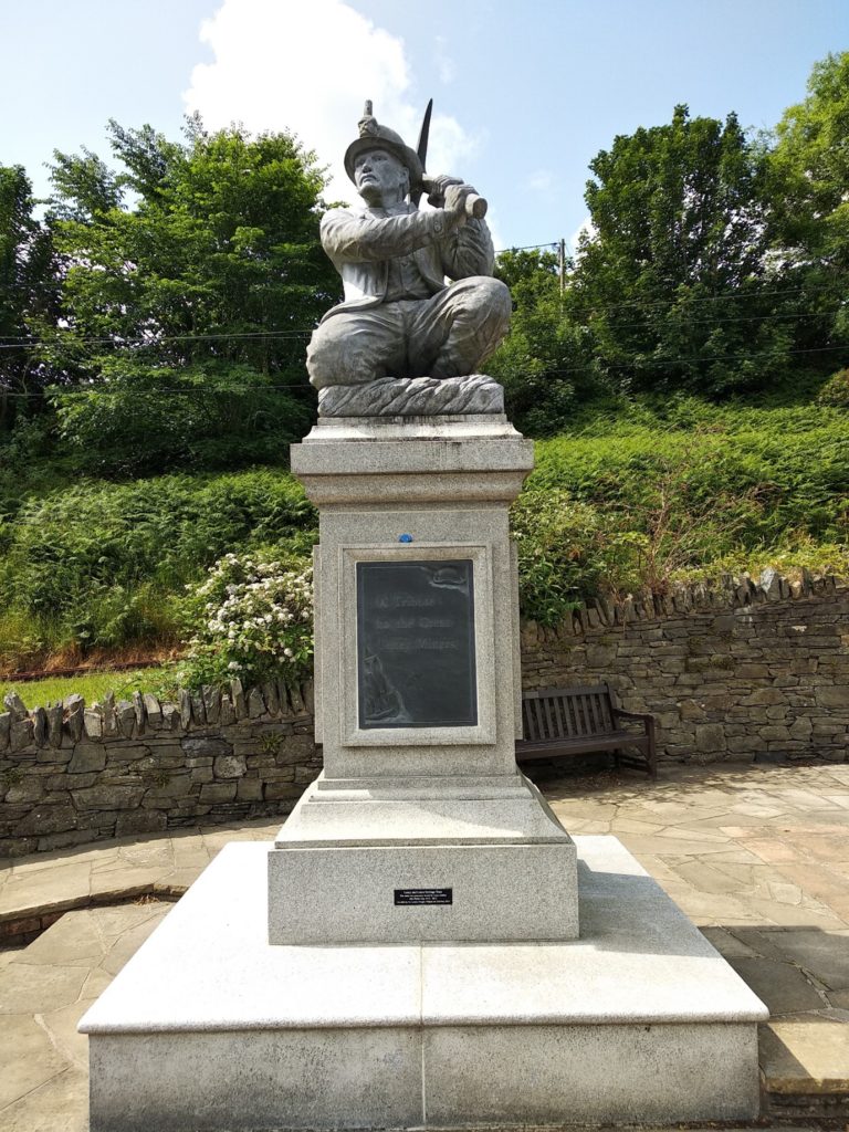 Sculture tribute to the Great Laxey niners showing a miner wielding a pick axe