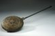 Image of a brass warming pan to warm beds with hot coals.